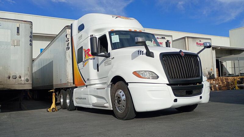 Tractocamión International de Transportes Reyes Romero con doble caja en un andén de carga